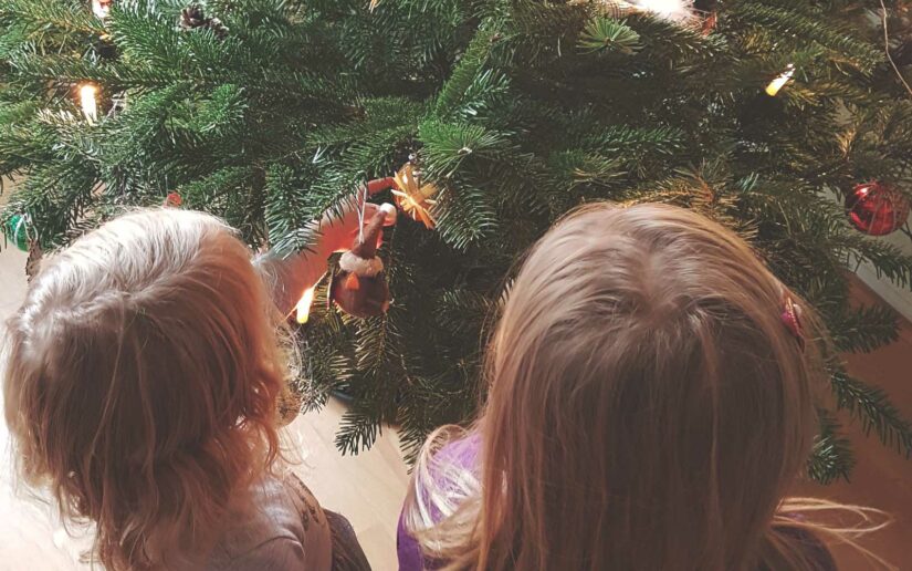 Kinder stehen vor Weihnachtsbaum